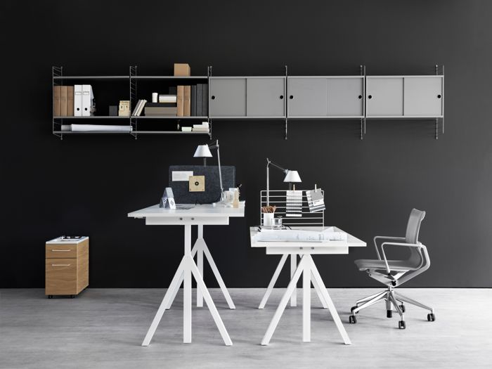 ENG
Wall mounted workspace solution from String. Height-adjustable work desk in white. Mobile storage in white. Wire screen in white. Fabric sleeve in grey felt. Freestanding shelf. Wall panels in grey. Shelves and cabinets with sliding doors in grey.
SWE
Väggmonterat hyllsystem för arbetsrum från String. Höj- och sänkbart skrivbord i vitt. Rullhurts i vitt. Raster i vitt. filthuv i grått. Fristående hylla. Väggavlar i grått. Hyllplan och skåp med skjutdörrar i grått.
DE
Wandhängende Arbeitsplatzlösung von String. Höhenverstellbare Schreibtischplatte in Weiß. Rollcontainer in Weiß. Leiterrückwand in Weiß. Stoffüberzug in grauem Filz. Freistehendes Regal. Wandleitern in Grau. Regalböden und Schrankelemente mit Schiebetüren in Grau.
FR
Solution pour espace de travail à fixer au mur signée String. Bureau ajustable blanc. Caisson de rangement mobile blanc. Grille en métal blanc. Panneau en feutrine gris. Étagère autoportante. Montants muraux gris. Étagères et caissons portes coulissantes gris.
ES
Solución de espacio de trabajo montada en pared de String. Escritorios de altura regulable en blanco Cajonera móvil en blanco. Organizador de rejilla metálica en blanco. Funda de tela en fieltro gris. Estante autoportante. Paneles de pared en gris. Estantes y cabinets con puertas correderas en gris.